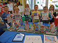  Students pose with handmade booklets and model of an urban community.
